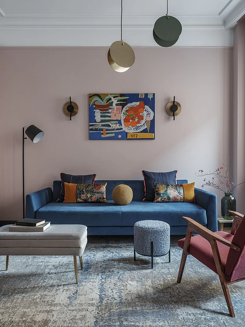 Темно-синій диван в класичному інтер'єрі з книжковими полицями