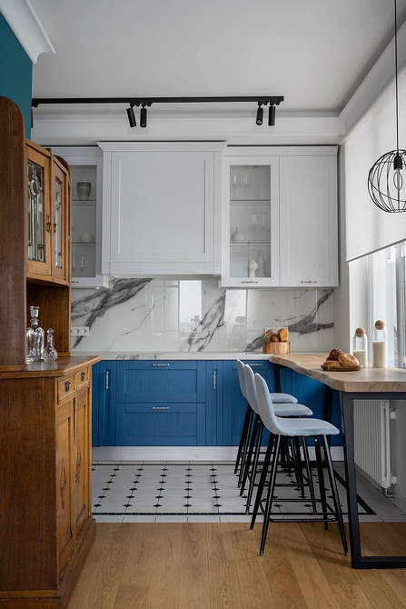 Вінтажний дерев'яний стіл та стільці в сучасній світлій їдальні.