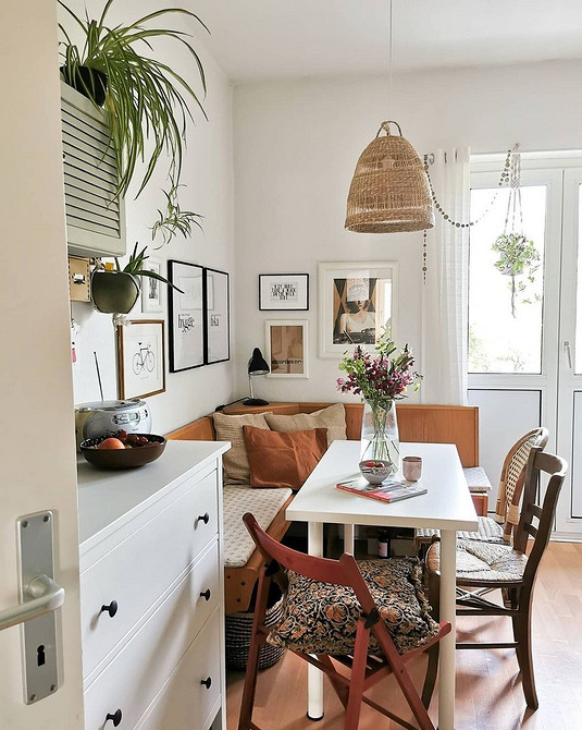 Сучасний кухонний куточок з диваном та обіднім столом для оптимізації простору.