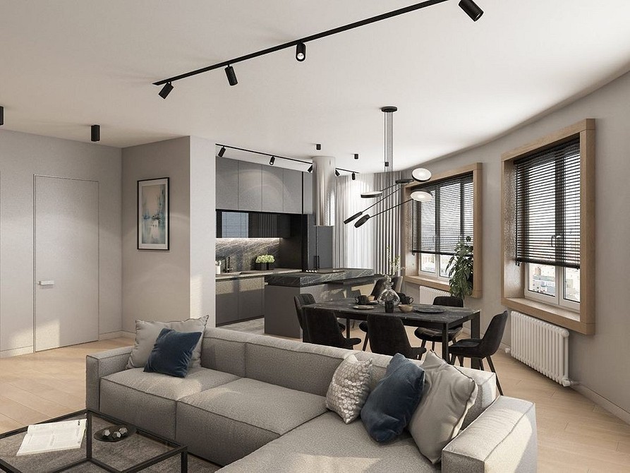 Світла вітальня з великим кутовим диваном та панорамними вікнами.