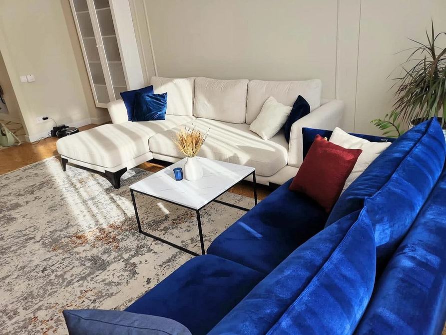 Інтер'єр вітальні з великим кутовим диваном та каміном, дизайн