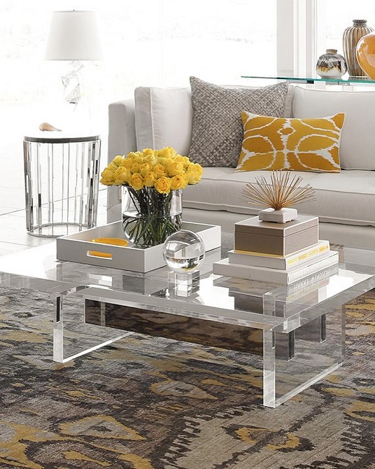 Сучасний журнальний столик з прозорого пластику у мінімалістичній вітальні.