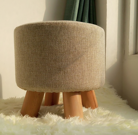 Сучасний інтер'єр з пуфом та кріслом біля вікна, освітлений сонячним світлом