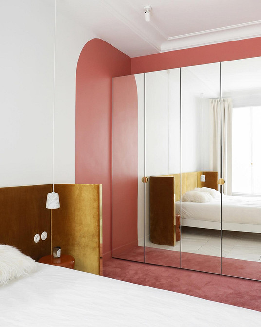 Сучасна шафа з дзеркальними дверцятами в інтер'єрі спальні, що візуально збільшує простір.