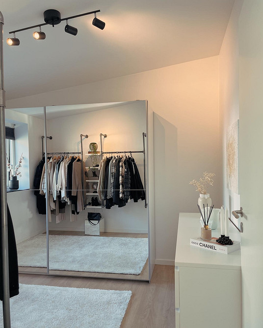 Сучасна шафа з дзеркалом у світлій спальні, що візуально збільшує простір.