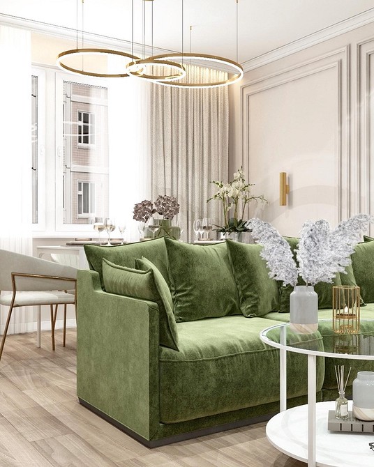 Дизайн маленької квартири з зеленим диваном та світлими меблями