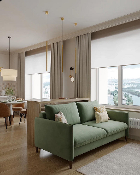 Зелений кутовий диван у вітальні з великими вікнами та натуральним освітленням