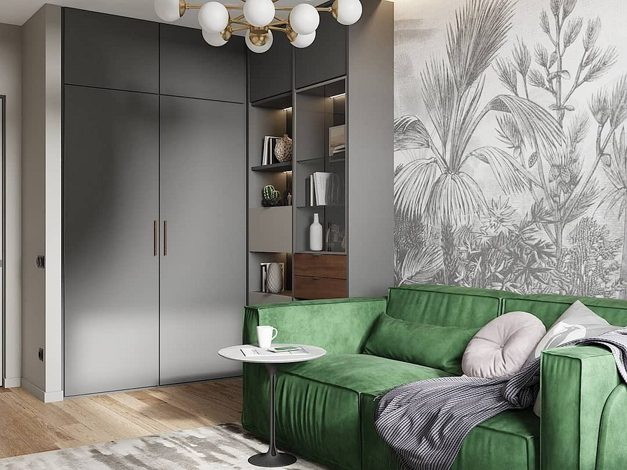 Вітальня з великим кутовим зеленим диваном, журнальним столиком та книжковою полицею.