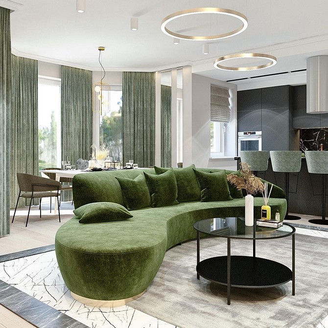 Інтер'єр з зеленим диваном, книжковою шафою та килимом в теплих тонах