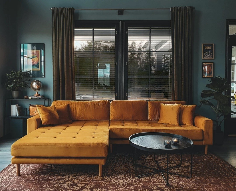 Невеликий жовтий диван у маленькій вітальні з яскравими акцентами