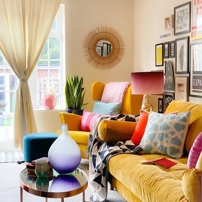 Стильний дизайн вітальні з жовтим диваном та декоративними подушками різних кольорів