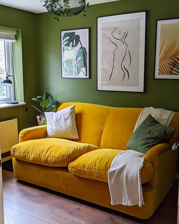 Жовтий велюровий диван з подушками в інтер'єрі у стилі бохо виглядає розкішно