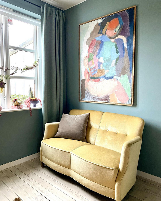 Інтер'єр з жовтим диваном, геометричним килимом та дерев'яним столиком виглядає гармонійно