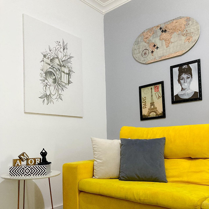 Затишний інтер'єр з жовтим диваном, дерев'яним столиком та декоративними подушками у вітальні.