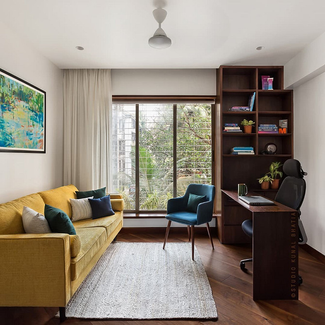 Жовтий диван з геометричними подушками у вітальні з сучасним дизайном і декором.