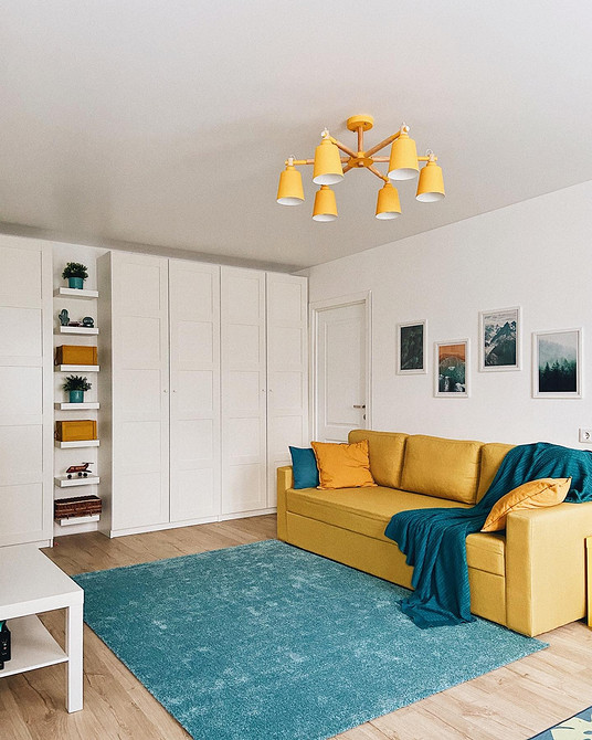 Жовтий велюровий диван з декоративними подушками різних кольорів та текстур додає комфорту.