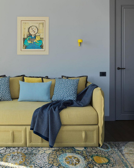 Стильний жовтий диван в сучасному інтер'єрі з дерев'яною підлогою та яскравим килимом.