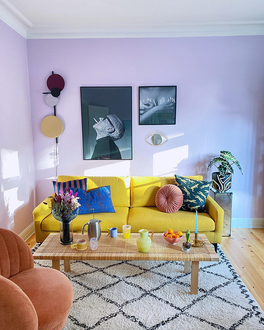 Жовтий диван в скандинавському стилі з дерев'яними ніжками та світлим текстилем.