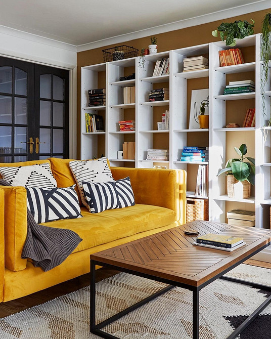 Жовтий диван у вітальні з яскравими акцентами та скандинавським стилем