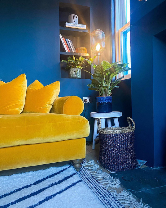 Невеликий жовтий диванчик в дитячій кімнаті з іграшками та барвистим декором.