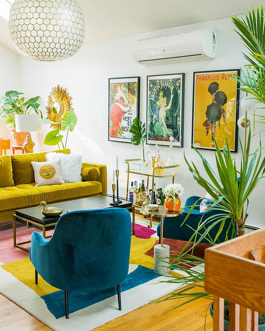 Жовтий диван з дерев'яними ніжками в скандинавському інтер'єрі з мінімалістичним декором.