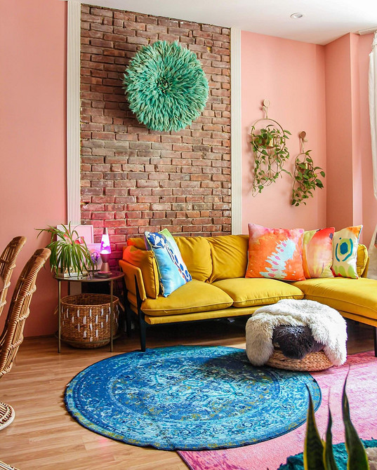 Жовтий диван в дитячій кімнаті з іграшками та різнокольоровими акцентами