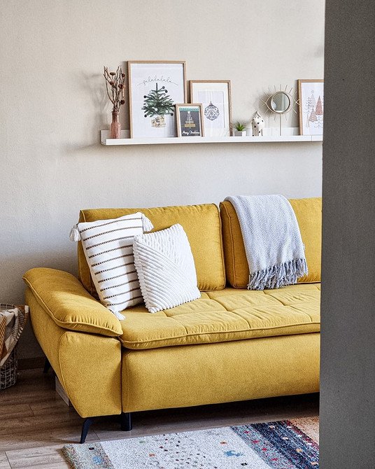 Інтер'єр з жовтим диваном, килимом з геометричним візерунком та декоративними подушками додає акценту.